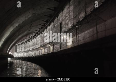 Das Innere des Industrietunnels aus grauem Beton ist Teil einer verlassenen U-Boot-Basis aus der UdSSR. Balaklava, Krim Stockfoto