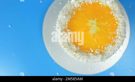 Kuchen mit Orange- und Kokosspäne auf blauem Hintergrund. Stockfoto