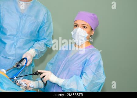 Chirurg führt minimalinvasive laparoskopische Operationen durch. Eine Ärztin im Operationssaal operiert einen Patienten mit Hilfe von chirurgischen Manipulatoren. Selektiver Fokus. Stockfoto