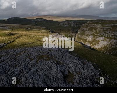 Unvergleichliche Aussicht auf Kalksteinpflaster in der Nähe von Malham mit Comb Hill und Dean Moor Hill in der Ferne Stockfoto