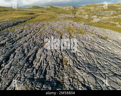 Unvergleichliche Aussicht auf Kalksteinpflaster in der Nähe von Malham mit Comb Hill und Dean Moor Hill in der Ferne Stockfoto