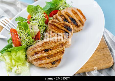 Fleisch mit Gemüse. Schweinemedaillons. Gegrilltes Fleisch. Cutlets close-up. Rindfleisch Stockfoto