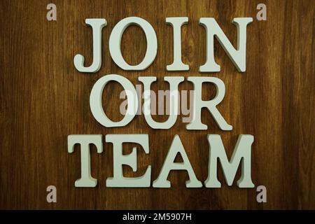 Schließen Sie sich unserem Team an, das aus Holzwürfeln mit Buchstaben und Buchstaben besteht Stockfoto