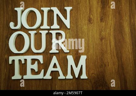 Schließen Sie sich unserem Team an, das aus Holzwürfeln mit Buchstaben und Buchstaben besteht Stockfoto