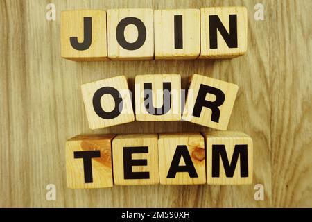 Schließen Sie sich unserem Team an, das aus Holzwürfeln mit Buchstaben und Buchstaben besteht Stockfoto
