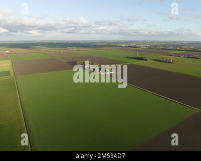 Landwirtschaft modernes Bauernhaus in einem weitläufigen, leeren, grünen Feld. Panoramaantenne über dem Kopf, weite, offene Sicht. Stockfoto