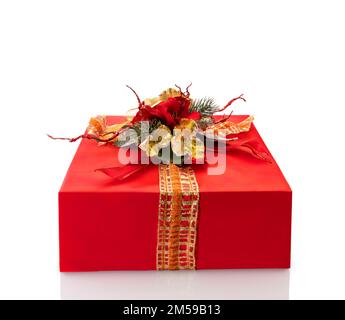 Rote Geschenkbox mit Schleife und goldenen Fake-Blumen und Pinienzweigen. Weihnachtsgeschenk. Isoliert auf weiß mit Beschneidungspfad, Kopierbereich Stockfoto