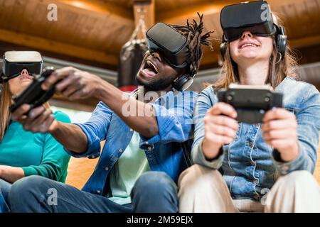 Fröhliche Freunde, die mit dem virtuellen Simulator Spaß an modernen Spielen haben, eine Gruppe von Genz-Leuten, die neue Technologie für Augmented-Reality-sim nutzen Stockfoto