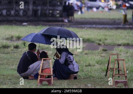 27. Dezember 2022, Yogyakarta, Sonderregion von Yogyakarta, Indonesien: Eltern schwingen ihre Kinder, die in Yogyakarta malen. Die National Disaster Management Agency (BNPB) erinnert die Menschen daran, bei extremen Wetterbedingungen, wie starkem Regen, Überschwemmungen und Stürmen, nicht auf Reisen oder Jahresferien zu bestehen. BNPB prognostiziert extreme Wetterbedingungen in Form von starkem Regen und Stürmen am Mittwoch (28. Oktober 12) morgen. BNPB wird außerdem Wettermodifizierungstechnologien einsetzen, um extremen Wetterbedingungen vorzubeugen. Auch die Agentur für Meteorologie, Klimatologie und Geophysik (BMKG) fragte das Publi Stockfoto