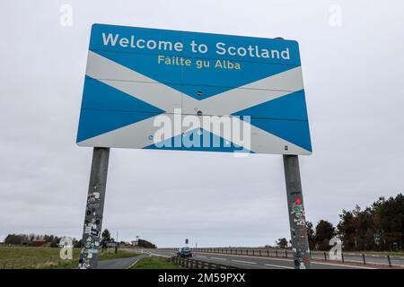 Riesig,groß,groß,massiv,Willkommen in Schottland,Failte gu Alba,Flagge,auch bekannt als Saltire, stammt aus dem 12. Jahrhundert,Beschilderung,Wegweiser,AT,Grenze,zwischen Schottland und dem Verlassen Englands,Flagge,auch bekannt als Saint Andrew's Cross, oder die Crux Decussata, ist ein heraldisches Symbol in Form eines diagonalen Kreuzes. Stockfoto