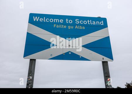 Riesig,groß,groß,massiv,Willkommen in Schottland,Failte gu Alba,Flagge,auch bekannt als Saltire, stammt aus dem 12. Jahrhundert,Beschilderung,Wegweiser,AT,Grenze,zwischen Schottland und dem Verlassen Englands,Flagge,auch bekannt als Saint Andrew's Cross, oder die Crux Decussata, ist ein heraldisches Symbol in Form eines diagonalen Kreuzes. Stockfoto