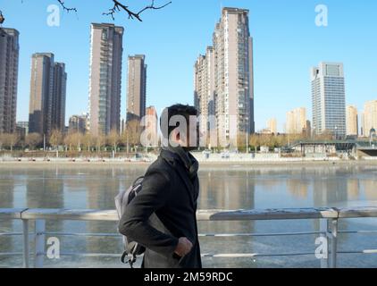 (221227) -- TIANJIN, 27. Dez. 2022 (Xinhua) -- Muhammad Nabil geht am Haihe River in Nordchina Tianjin entlang, 26. Dez. 2022. Muhammad Nabil ist ein pakistanischer Student an der Nankai-Universität in Tianjin. 2018 entschied er sich, nach Tianjin zu kommen, um für seinen Doktortitel zu studieren, nicht nur, um hier eine gute Ausbildung zu erreichen, sondern auch, um seinen Traum zu erfüllen, die chinesische Kampfkunst, oder Kung Fu, zu jagen. Muhammad Nabil sagte, er sei ein Fan von Huo Yuanjia, einem renommierten chinesischen Meister der Kampfkunst, geworden, nachdem er sich chinesische Kung-Fu-Filme in Pakistan angeschaut hatte. Während seines Studiums in Tianjin kam er in die Stadt Jingwu, Huo Yuanjias Heimatstadt Stockfoto