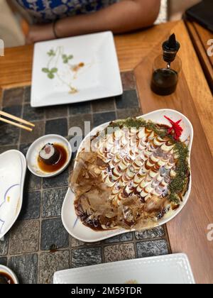 Okonomiyaki - ein japanisches, herzhaftes Pfannkuchengericht aus einem hohen Winkel Stockfoto