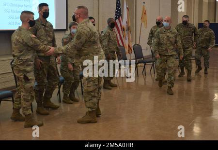 Captain Cameron Worley, der Einsatzleiter des Teams, schüttelt nach der Einsatzzeremonie mit Colonel Tim Newman, dem 108. Sustainment Brigade Commander, die Hand. Ein Logistikberaterteam aus fünf Soldaten des 6. Bataillons der Illinois Army National Guard, 54. Security Force Assistance Brigade (SFAB) hielt am Sonntag, den 13. Februar, eine Einsatzzeremonie in Rock Island Arsenal, Illinois, ab. Nach einer kurzen Schulung in Texas wird das Team mit dem 5. SFAB der aktiven Armee in der Joint Base Lewis-McChord, Washington, zusammenarbeiten, um in der Mongolei zu stationieren. Die sechsmonatige Entsendung ist die erste für die Illin Stockfoto