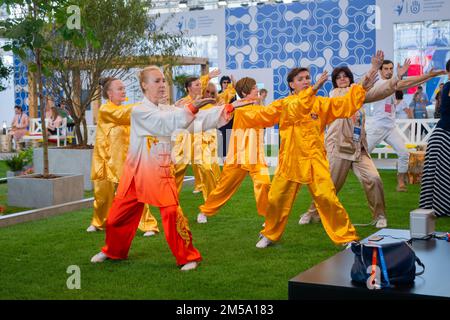 Eine Gruppe von Menschen, die gemeinsam Qigong-Übungen auf der Ausstellung machen Stockfoto