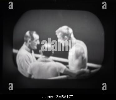 Ende 1950er, historisch, ein Fernsehset der Epoche, das ein Boxkampf zeigt, der Schiedsrichter spricht mit einem Boxer in seiner Ecke. Höchstwahrscheinlich ein Clip von Sportsview, einer BBC-Sportsendung Mitte der Woche, präsentiert von Peter Dimmock, die von 1954 bis 1968 ausgestrahlt wurde. Stockfoto