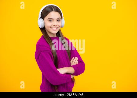 Kindermusik-Konzept. Teenager Kind Mädchen tanzt im Rhythmus der Melodie, hört Lied in Kopfhörern. Kind hört Musik über Kopfhörer. Stockfoto