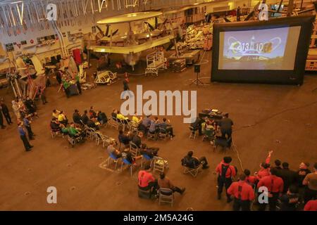 PHILIPPINISCHE SEE (14. Februar 2022) Seeleute sehen den Super Bowl LVI während einer Veranstaltung in der Hangarbucht an Bord des Flugzeugträgers USS Abraham Lincoln (CVN 72) der Nimitz-Klasse. Die Abraham Lincoln Strike Group befindet sich in einem geplanten Einsatz im US-7.-Flottenbereich, um die Interoperabilität durch Allianzen und Partnerschaften zu verbessern und gleichzeitig als einsatzbereite Truppe zur Unterstützung einer freien und offenen Region Indo-Pacific zu fungieren. Stockfoto