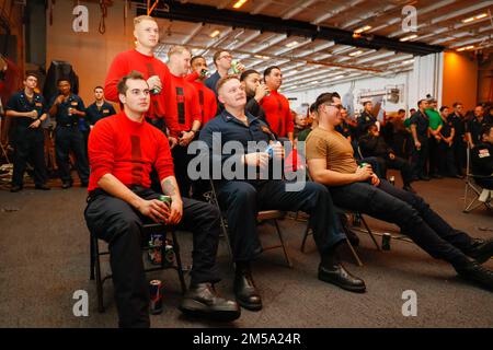 PHILIPPINISCHE SEE (14. Februar 2022) Seeleute sehen den Super Bowl LVI während einer Veranstaltung in der Hangarbucht an Bord des Flugzeugträgers USS Abraham Lincoln (CVN 72) der Nimitz-Klasse. Die Abraham Lincoln Strike Group befindet sich in einem geplanten Einsatz im US-7.-Flottenbereich, um die Interoperabilität durch Allianzen und Partnerschaften zu verbessern und gleichzeitig als einsatzbereite Truppe zur Unterstützung einer freien und offenen Region Indo-Pacific zu fungieren. Stockfoto