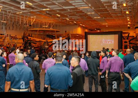 PHILIPPINISCHE SEE (14. Februar 2022) Seeleute sehen den Super Bowl LVI während einer Veranstaltung in der Hangar Bay an Bord der USS Abraham Lincoln (CVN 72). Die Abraham Lincoln Strike Group befindet sich in einem geplanten Einsatz im US-7.-Flottenbereich, um die Interoperabilität durch Allianzen und Partnerschaften zu verbessern und gleichzeitig als einsatzbereite Truppe zur Unterstützung einer freien und offenen Region Indo-Pacific zu fungieren. Stockfoto