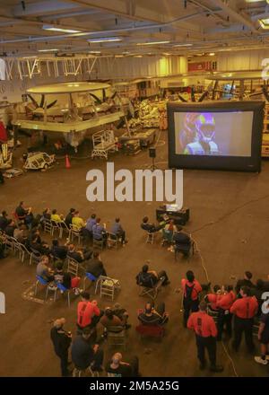 PHILIPPINISCHE SEE (14. Februar 2022) Seeleute sehen den Super Bowl LVI während einer Veranstaltung in der Hangarbucht an Bord des Flugzeugträgers USS Abraham Lincoln (CVN 72) der Nimitz-Klasse. Die Abraham Lincoln Strike Group befindet sich in einem geplanten Einsatz im US-7.-Flottenbereich, um die Interoperabilität durch Allianzen und Partnerschaften zu verbessern und gleichzeitig als einsatzbereite Truppe zur Unterstützung einer freien und offenen Region Indo-Pacific zu fungieren. Stockfoto