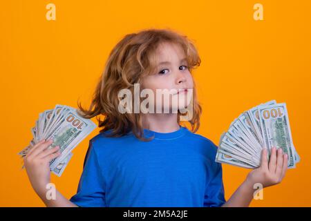 Der Junge hat viele hundert Dollar isoliert auf gelbem Hintergrund. Stockfoto