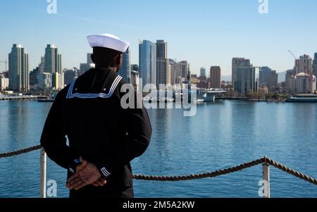 220214-N-MD461-1150 SAN DIEGO (14. Februar 2022) Aviation Support Equipment Technician 3. Class Chris Adingwu, ein Einheimischer aus Delta State, Nigeria, mans die Schienen an Bord des Flugzeugträgers USS Carl Vinson der Nimitz-Klasse, wenn er zu seinem Homeport in San Diego, Kalifornien, zurückkehrt Die Carl Vinson Carrier Strike Group kehrte nach einem achtmonatigen Einsatz in den US-Flotten 3. und 7. nach San Diego zurück, um die regionale Stabilität und eine freie und offene Region Indo-Pacific zu unterstützen. Stockfoto