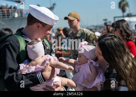 220214-N-US228-1005 SAN DIEGO (14. Februar 2022) Seeleute, die dem Ticonderoga-Klasse-Guided-Raketen-Kreuzer USS Lake Champlain (CG 57) zugeteilt sind, begrüßen ihre Familien nach der Rückkehr zum Homeport auf der Marinebasis San Diego. Lake Champlain, Teil der Carl Vinson Carrier Strike Group, kehrte am 14. Februar nach einem Einsatz in den US-Flotten 3. und 7. zur Unterstützung der regionalen Stabilität und eines freien und offenen Indo-Pacific zum Marinestützpunkt San Diego zurück. Stockfoto