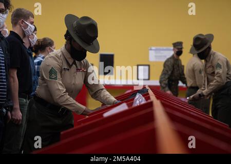 USA Marine Corps Gunnery Sgt. Vernita M. Finley, leitender Ausbilder bei der Receiving Company, Support Battalion, inspiziert während des Recruits im Marine Corps Recruit Depot, San Diego, 14. Februar 2022 das Eigentum neuer Rekruten. Zu dieser Zeit leerten die Rekruten ihre Taschen und ließen alles zur Untersuchung in den roten Mülleimern. Die Ausbilder nahmen sich die Zeit, um sicherzustellen, dass alle Schmuggelware konfisziert wurde, bevor sie mit dem Empfangsprozess fortfahren. Stockfoto