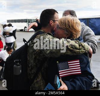 MARINEFLUGSTATION WHIDBEY ISLAND, WASHINGTON. - Aviation Electronics Technician 2. Class Clayton Tolle, zugewiesen zu den "Handschuhen" des Electronic Attack Squadron (VAQ) 136 begrüßt seine Familie nach seiner Rückkehr zur Naval Air Station Whidbey Island, Washington, Februar 14; Nach einem achtmonatigen Einsatz in den Flottenbereichen 3. und 7. der USA als Teil der Carl Vinson Carrier Strike Group. Stockfoto