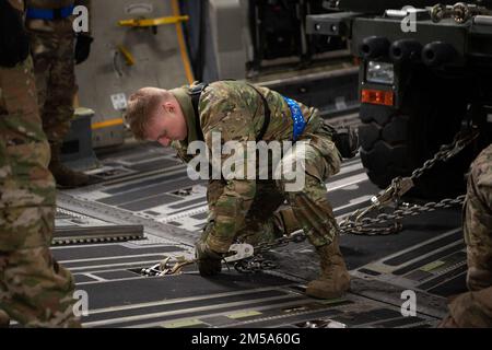 USA Air Force Senior Airman Jacob Rowan, 60. Aerial Port Squadron Ramp Operator, kettet Fracht auf einen C-17 Globemaster III, der Joint Base Lewis-McChord, Washington, am Luftwaffenstützpunkt Travis, Kalifornien, am 14. Februar 2022 zugeteilt ist. USA Flugzeuge mit der 60. Hafenstaffel und der 8. Luftaufzugsstaffel haben Fracht auf die C-17 geladen. Unter der Leitung der USA Transportation Command, der 60. Air Mobility Wing unterstützte den 621. Contingency Response Wing während der Beförderung von Fracht aus Sicherheitskräften in die Ukraine mit gewerblichen Frachtflugzeugen. Die Agentur für die Zusammenarbeit im Verteidigungsbereich koordinierte das e Stockfoto