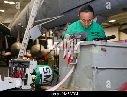 PHILIPPINE SEA (15. Februar 2022) Aviation Structural Mechanic 2. Class Diana Farias aus Miami, zugewiesen zu den „Wizards“ des Electronic Attack Squadron (VAQ) 133, führt an einem EA-18G Growler in der Hangarbucht an Bord des Flugzeugträgers USS Abraham Lincoln (CVN 72) der Nimitz-Klasse einen Korrosionstest durch. Die Abraham Lincoln Strike Group befindet sich in einem geplanten Einsatz im US-7.-Flottenbereich, um die Interoperabilität durch Allianzen und Partnerschaften zu verbessern und gleichzeitig als einsatzbereite Truppe zur Unterstützung einer freien und offenen Region Indo-Pacific zu fungieren. Stockfoto