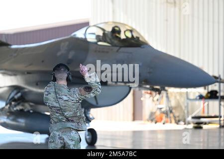 Airman 1. Class Holden Wylie, 8. Aircraft Maintenance Unit F-16 Viper Assistant engagierter Crewchef, startet eine F-16, die der 8. Kampfeinheit am 14. Februar 2022 auf der Holloman Air Force Base, New Mexico, zugewiesen ist. Dieser Start ist der 100. Flug der AMU im Jahr 8., nachdem ihre Instandhaltungspersonal von Auftragnehmern auf aktive Flugzeuge umgestellt wurden. (Foto: Senior Airman Adrian Salazar) Stockfoto