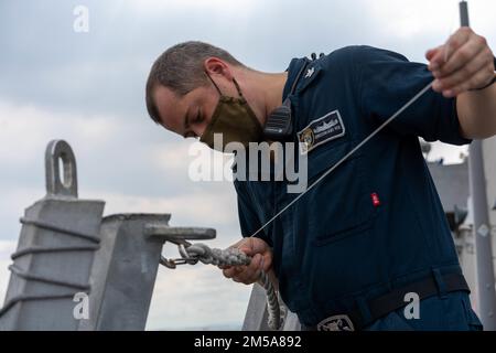 220215-N-FA490-1319 MANILA, Philippinen (15. Februar 2022) – Boatswain’s Mate 2. Klasse Patrick Hix, aus Independence, Missouri, hält eine Rettungslinie auf dem Cockpit des Küstenschiffes USS Jackson (LCS 6). Am Destroyer-Geschwader (DESRON) 7 beteiligt, befindet sich Jackson im Rotationseinsatz im US-7.-Flottengebiet, um die Sicherheit und Stabilität in der Region zu unterstützen. Und mit den alliierten und Partnerschifffahrtsleuten zusammenzuarbeiten, um die Sicherheit und Stabilität des Seeverkehrs zu gewährleisten, die Grundpfeiler eines freien und offenen Indopazifiks. Stockfoto