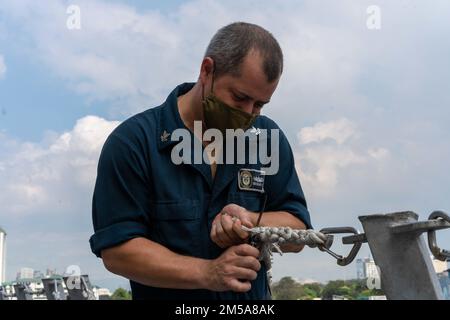 220215-N-FA490-1351 MANILA, Philippinen (15. Februar 2022) – Boatswain's Mate 2. Klasse Patrick Hix, aus Independence, Missouri, schneidet die ausgefransten Kanten an einer Rettungslinie auf dem Cockpit des Küstenschiffes USS Jackson (LCS 6) der Independence-Variant. Am Destroyer-Geschwader (DESRON) 7 beteiligt, befindet sich Jackson im Rotationseinsatz im US-7.-Flottengebiet, um die Sicherheit und Stabilität in der Region zu unterstützen. Und mit den alliierten und Partnerschifffahrtsleuten zusammenzuarbeiten, um die Sicherheit und Stabilität des Seeverkehrs zu gewährleisten, die Grundpfeiler eines freien und offenen Indopazifiks. Stockfoto