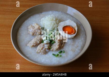 Congee mit gesalzenem Ei und Fleischklößchen Stockfoto