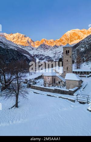 Sonnenaufgang vor Monte Rosa von der alten Kirche Macugnaga im Winter. Valle Anzasca, Ossola, Provinz Verbania, Piemont, italienische alpen, Italien. Stockfoto