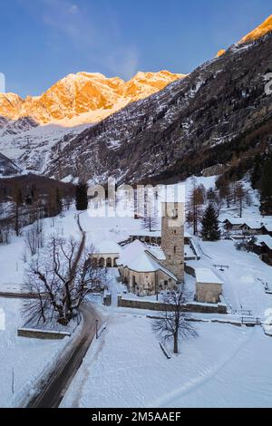 Sonnenaufgang vor Monte Rosa von der alten Kirche Macugnaga im Winter. Valle Anzasca, Ossola, Provinz Verbania, Piemont, italienische alpen, Italien. Stockfoto