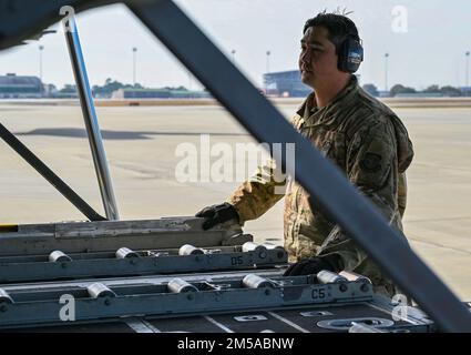 USA Air Force Tech. Sgt. Sean Stalnaker, ein Airman bei der Logistik-Bereitschaftsstaffel am 165. Luftschiff, Georgia National Guard, leitet die Fracht, die auf eine C-130 Hercules geladen wird, bevor sie am 15. Februar 2022 in Savannah, Georgia, eingesetzt wird. Der von der Georgia National Guard dekorierte 165. Airlift Wing unterstützt die USA Air Forces Europe befehlshabt durch Bereitstellung logistischer Unterstützung und eines taktischen Lufttransportpakets zur Bereitstellung militärischer Hilfe. Der C-130H kann eine Vielzahl von Funktionen ausüben und von strengen Flugplätzen aus operieren. Stockfoto