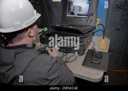 MARINESTÜTZPUNKT NORFOLK, VA (16. Februar 2022) Mike Amundson von der Puget Sound Naval Shipyard and Intermediate Maintenance Facility navigiert in einem ferngesteuerten Fahrzeug (ROV), das zur Inspektion eines Ballasttanks an Bord der USS Iwo Jima (LHD 7) verwendet wird. Das Mid-Atlantic Regional Maintenance Center (MARMC) veranstaltete eine Demonstration der Tankinspektion des ROV, an der zahlreiche Ingenieur- und Innovationsexperten teilnahmen, um Einblicke in die möglichen Auswirkungen dieser Technologie auf die Schiffswartung zu erhalten. Das MARMC leistet Bodenschiffinstandhaltung, -Management und -Aufsicht in Bezug auf die Instandhaltung des privaten Sektors sowie technische Flottenunterstützung für Schiffe in Stockfoto