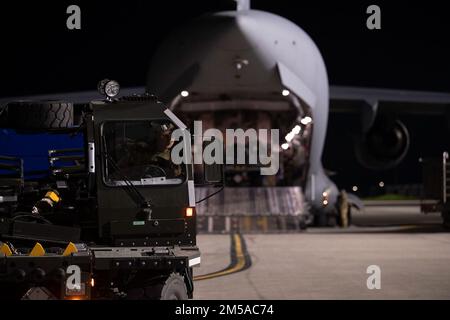 Jacob Rowan, Senior Airman der US Air Force, 60th Aerial Port Squadron Ramp Operator, fährt einen K-Lader auf der Travis Air Force Base, Kalifornien, 14. Februar 2022 in Richtung eines C-17 Globemaster III, der der Joint Base Lewis-McChord, Washington, zugewiesen wurde. U.S. Airmen mit dem 60th Aerial Port Squadron und 8th Airlift Squadron laden K-Lader auf die C-17. K-Lader werden verwendet, um Fracht in und aus Flugzeugen zu transportieren. Unter der Leitung des US Transportkommandos unterstützte der 60th Air Mobility Wing den 621st Contingency Response Wing während der Beförderung von Sicherheitsgütern in die Ukraine über kommerzielle Zwecke Stockfoto