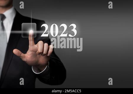 Neujahr 2023 – Drücken der virtuellen Touchscreen-Taste mit dem Finger Stockfoto