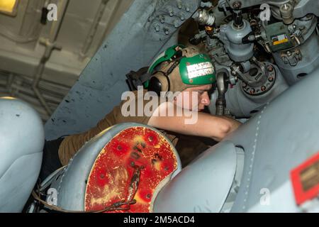 SOUTH CHINA SEA (15. Februar 2022) Aviation Machinist Mate 3. Class Sean Gibbens aus Texarkana, Texas, führt Wartungsarbeiten an einem MH-60R-Hubschrauber an Bord des Arleigh Burke-Class Guided Missile Destroyer USS Ralph Johnson (DDG 114) durch. Ralph Johnson ist der Task Force 71/Destroyer Squadron (DESRON) 15, dem größten nach vorn verlegten DESRON der Marine, und der Hauptstreitkraft der US-7.-Flotte zugewiesen. Stockfoto