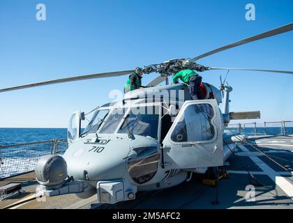 220215-N-EH998-1083 ATLANTISCHER OZEAN (Feb. 15,2022) Aviation Structrual Mechanic Airman Apprentice Jakob Ramsey, Left, Aviation Electronics Technician 3. Class Nicholas Stone, vorübergehend dem gesteuerten Raketenzerstörer USS Farragut (DDG 99) zugewiesen, führt während des Surface Warfare Advanced Tactical Training (SWATT) Vorflugkontrollen durch. Farragut ist Teil der Destroyer Squadron (DESRON) 26, die die Carrier Strike Group (CSG) 10 unterstützt. SWATT wird vom Naval Surface and Mine Warfighting Development Center (SMWDC) geleitet und soll die Kampffähigkeit, Letalität und Interop-Funktionalität verbessern Stockfoto