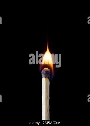 Makroaufnahme einer hölzernen Sicherheitsmatte, die mit einer hellen Flamme brennt Stockfoto