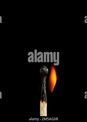 Makroaufnahme einer hölzernen Sicherheitsmatte, die mit einer orangefarbenen Flamme brennt Stockfoto