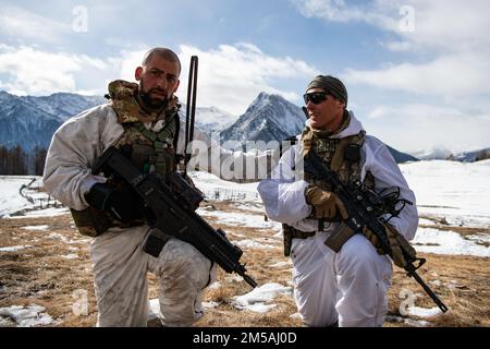 EIN US-AMERIKANISCHER Ein Fallschirmjäger der 1. Staffel, des 91. Kavallerie-Regiments (Airborne) und ein italienischer Soldat der 3. Alpini-Regiment-Verbindung, um die Exfiltration eines Ziels während eines integrierten Zugangriffs zu initiieren. Diese Ausbildung ist Teil der Übung Steel Blizzard am 17. Februar 2022 in Pian dell’Alpe in Usseaux, Italien. Exercise Steel Blizzard ist eine von der italienischen Armee veranstaltete multinationale Trainingsübung für Berg- und arktische Kriegsführung. Drei Aufklärungszüge der 173. Brigade nehmen an einem dreiphasigen Trainingsprogramm mit dem 3. Alpini-Regiment Teil, um das Capabili der Truppe zu erweitern Stockfoto