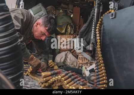 EIN US-AMERIKANISCHER Marine mit Marine Light Attack Helicopter Squadron (HMLA) 369 rüstet einen US-Luftraum wieder auf Marine Corps UH-1Y Venom Hubschrauber vor dem Start während der Jungle Warfare Übung (JWX 22) in IE Shima, Okinawa, Japan, 16. Februar 2022. JWX 22 ist eine groß angelegte Übung vor Ort, die darauf ausgerichtet ist, die integrierten Fähigkeiten gemeinsamer und verbundener Partner zu nutzen, um das Bewusstsein für alle Bereiche, Manöver und Brände in einer verteilten maritimen Umgebung zu stärken. Stockfoto