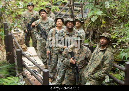 USA Marines mit Combat Logistics Battalion 4, Combat Logistics Regiment 3, 3. Marine Logistics Group, posieren für ein Gruppenfoto während der Jungle Warfare Übung 22, 16. Februar 2022, Camp Gonsalves, Okinawa, Japan. JWX 22 ist eine groß angelegte Schulung vor Ort, die darauf ausgerichtet ist, die integrierten Fähigkeiten gemeinsamer und verbundener Partner zu nutzen, um die Sensibilisierung für alle Bereiche, das Manövrieren und Brände in einer verteilten maritimen Umgebung zu stärken. Stockfoto