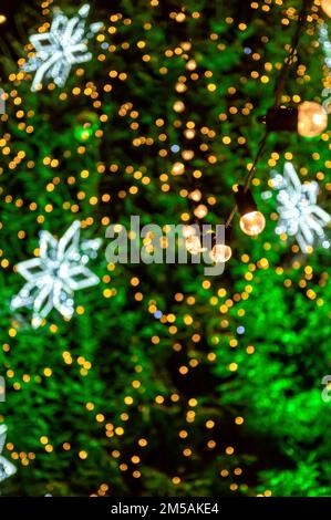 Girlande von Glühbirnen auf unscharfen weihnachtslichtern, geringe Schärfentiefe, Kopierraum Stockfoto
